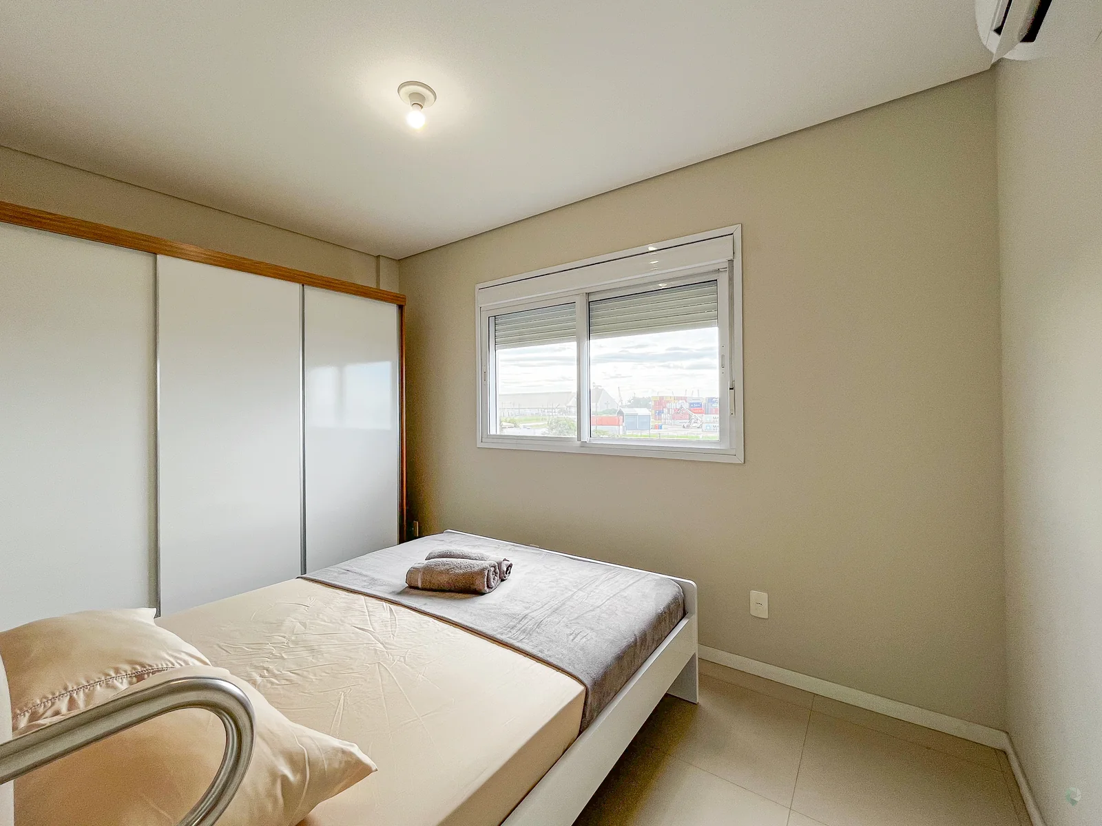 Dormitório com cama junto à janela